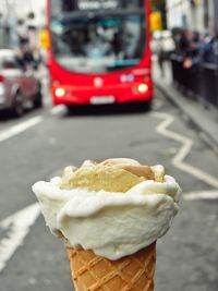 Close-up of hand holding ice cream on road