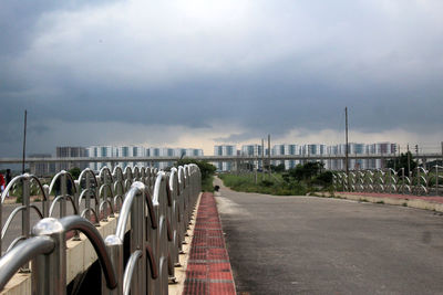 View of city street against cloudy sky