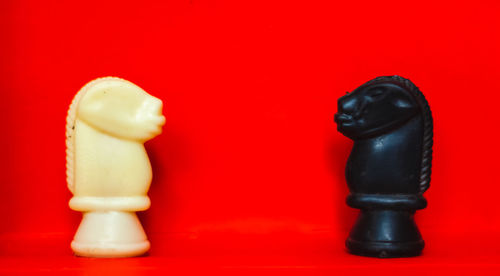 Close-up of chess pieces against red background