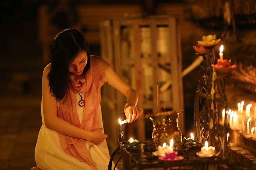 WOMAN WITH ILLUMINATED CANDLES
