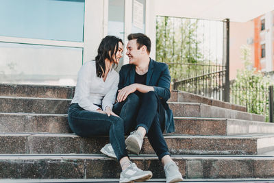 Young couple sitting on staircase