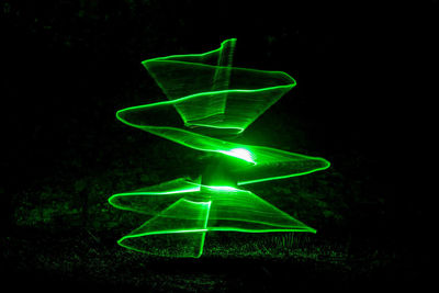 Close-up of illuminated light bulb against black background