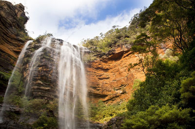 Scenic view of waterfall against sky