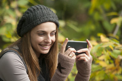 Portrait of young woman holding phone