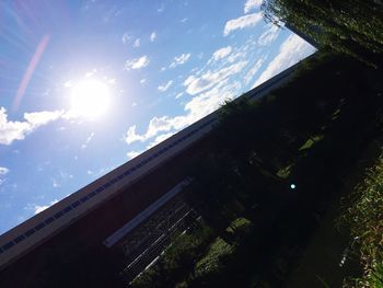 Low angle view of sun shining through clouds