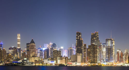 Illuminated buildings in city against sky