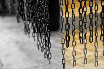 Close-up of chain hanging on metal fence