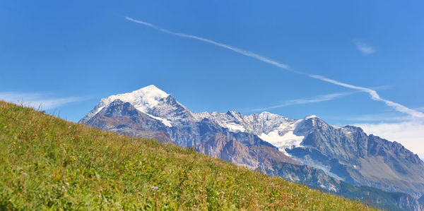 Scenic view of snowcapped mountains against blue sky