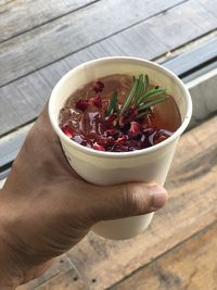 High angle view of hand holding food on table