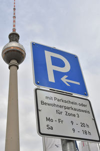 Low angle view of information sign against sky