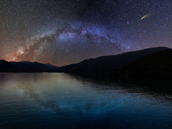 Scenic view of lake against sky at night