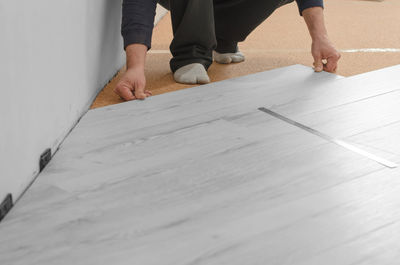 Professional installs laminate. unrecognizable man laying laminate flooring.
