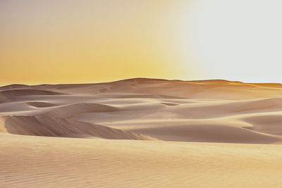 Sand dunes in desert against clear sky