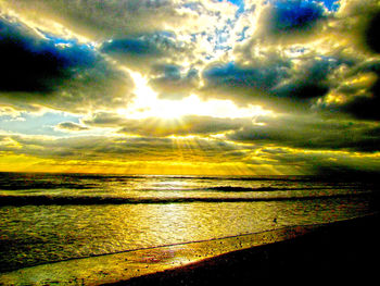 Scenic view of sea against dramatic sky during sunset