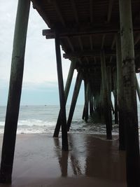 Scenic view of beach and bridge against sky