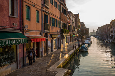 People in canal along buildings