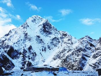 Scenic view of snow covered mountains against blue sky