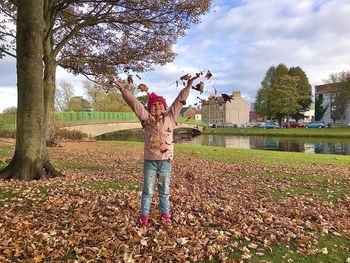 Full length of boy standing by tree during autumn