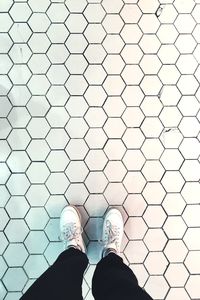 Low section of man standing on tiled floor