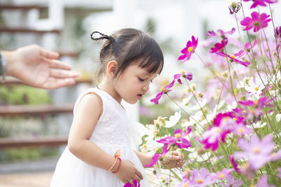 Side view of young woman holding flowers