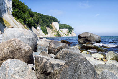Rocks by sea against sky