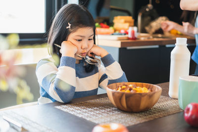 Cute girl having food at home