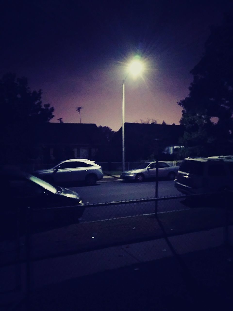 CARS ON ROAD AGAINST SKY AT NIGHT