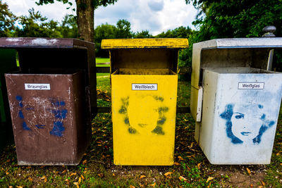 Colorful garbage cans on field