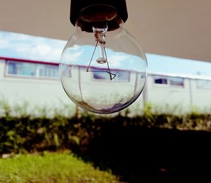 Close-up of light bulb against building