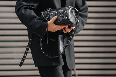 Midsection of man holding umbrella