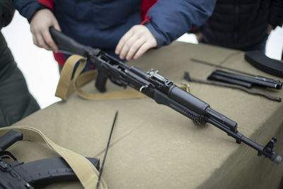 Midsection of man holding gun