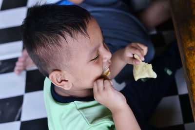 Close-up of boy eating food at home