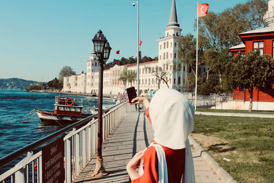 Man on railing against buildings in city