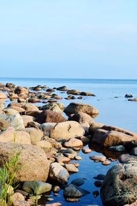 Rocks in sea against clear sky