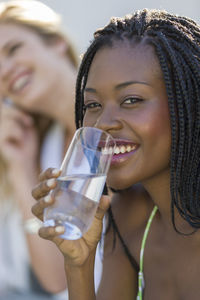 Portrait of a smiling young woman drinking glass