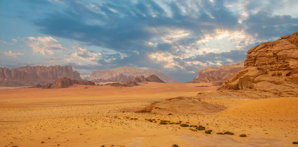 Red sands, mountains, dramatic sky and marthian landscape panorama of wadi rum desert, jordan