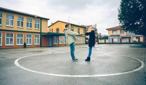 People standing on street against buildings in city