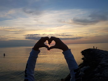 Woman hand on beach during sunset