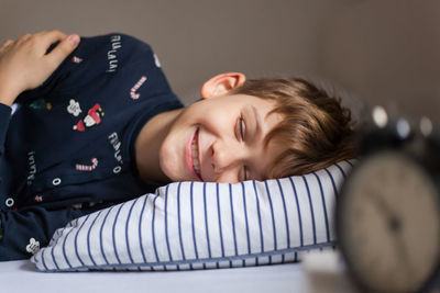 Portrait of smiling boy sleeping in his bed at home