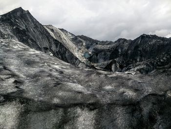 Scenic view of mountains against cloudy sky