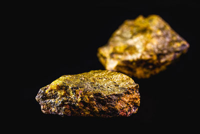 Close-up of bread on rock against black background