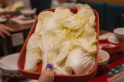 Close-up of hand holding ice cream in restaurant