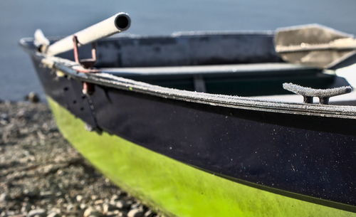 Close-up of fishing boat moored on shore