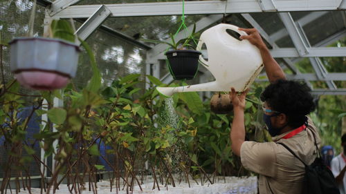 Midsection of man working by plants