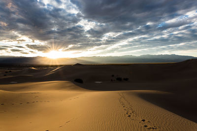 Scenic view of desert against sky during sunset