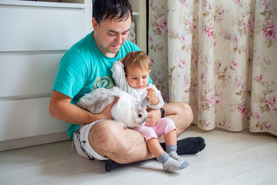 Siblings sitting on floor at home