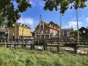 Houses by buildings against sky in city