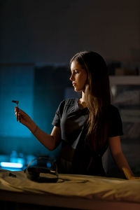 Young woman using mobile phone at table