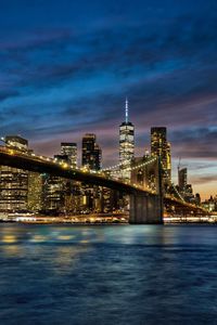 Illuminated bridge over river at night