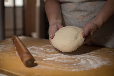 Midsection of person preparing pastry on table